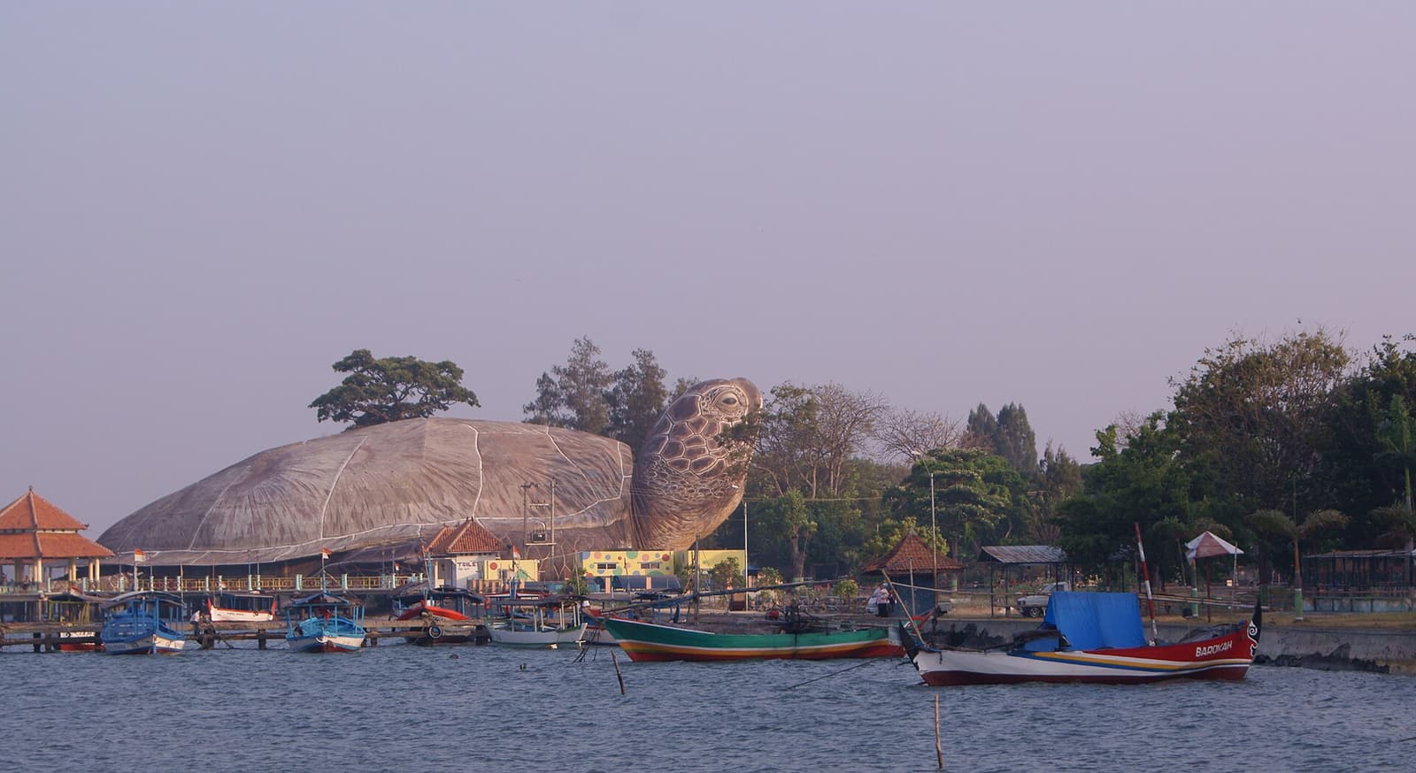 The giant turtle-shaped building at Kartini Beach in Jepara, with boats in front