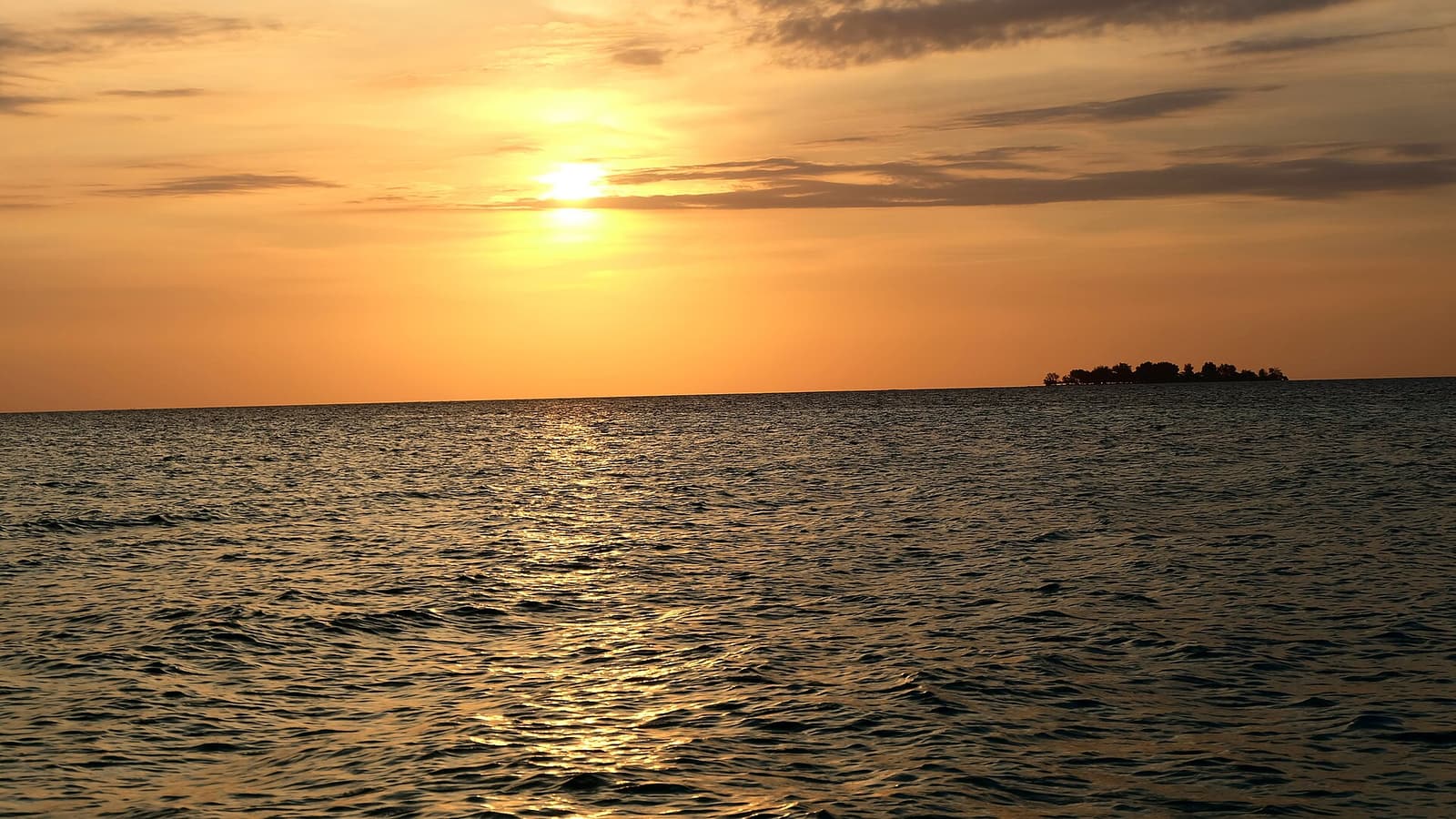 The sun setting over a calm sea in Karimunjawa