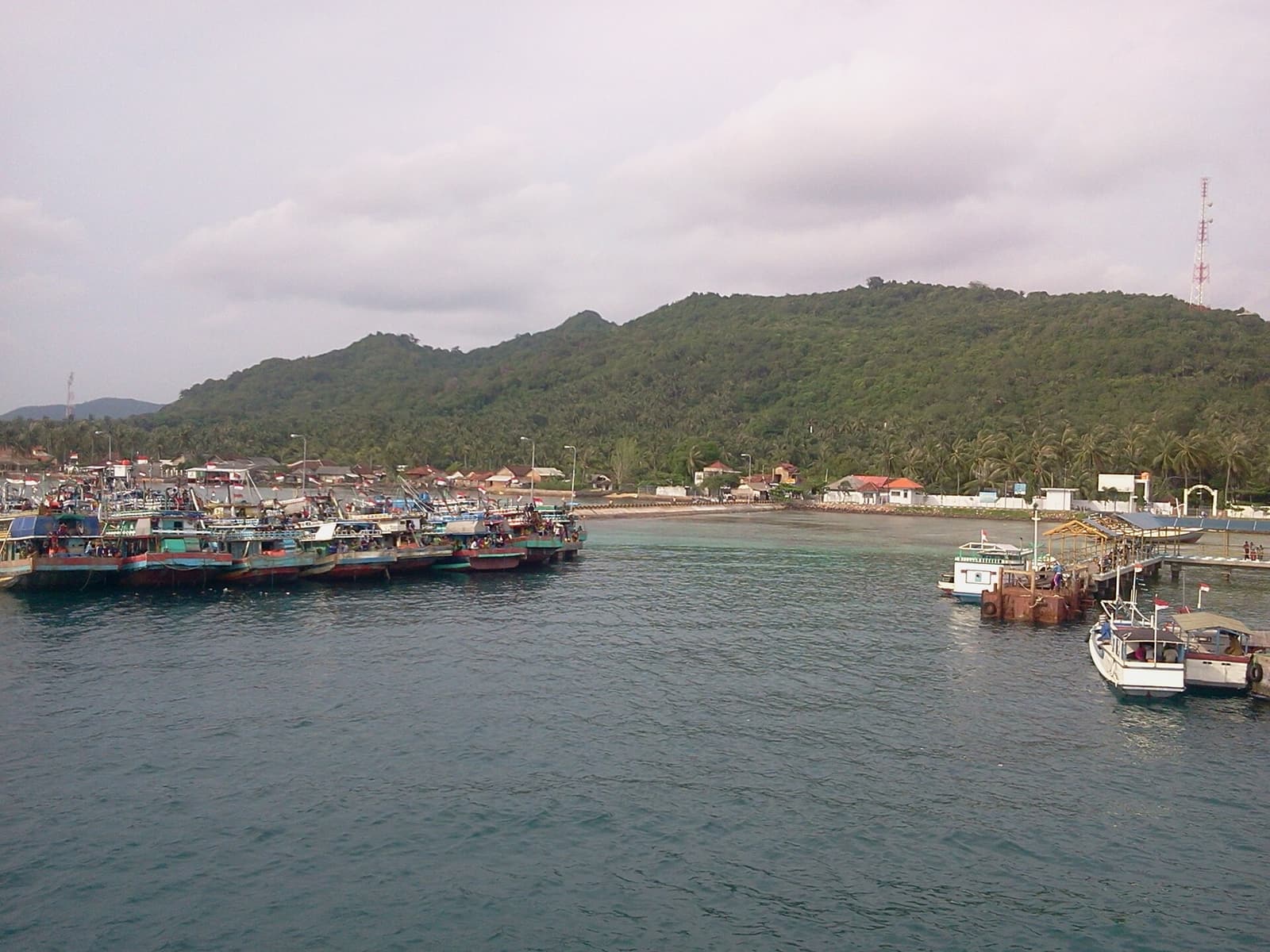 Fishing boats in Karimunjawa harbour below forested hills